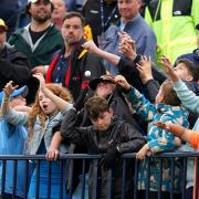 Young fans attempt to grab a ball thrown into the crowd by USA's Brian Harman on the 18th green during day three of The Open at Royal Liverpool, Wirral