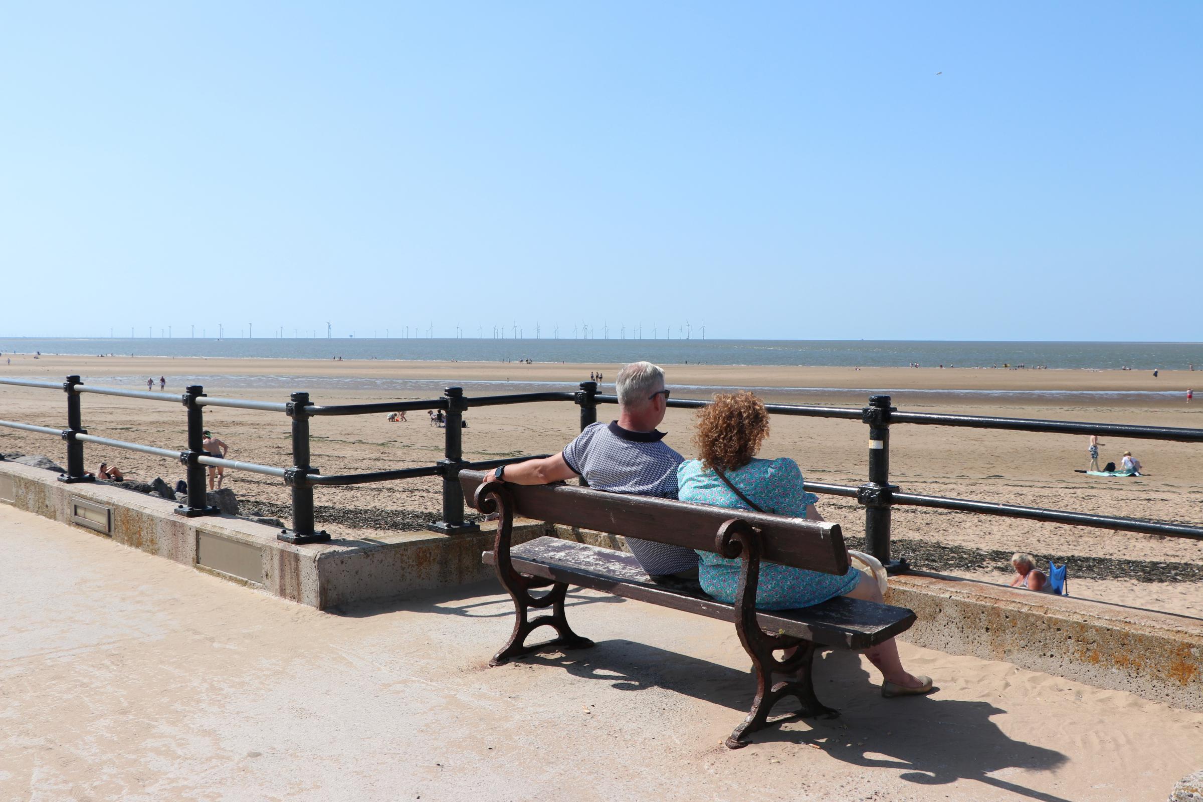 A couple take in the view in New Brighton the day that Covid restrictions are lifted across England