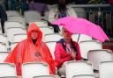 Fans shelter from the rain on day five of the fourth LV= Insurance Ashes Series test match at Emirates Old Trafford
