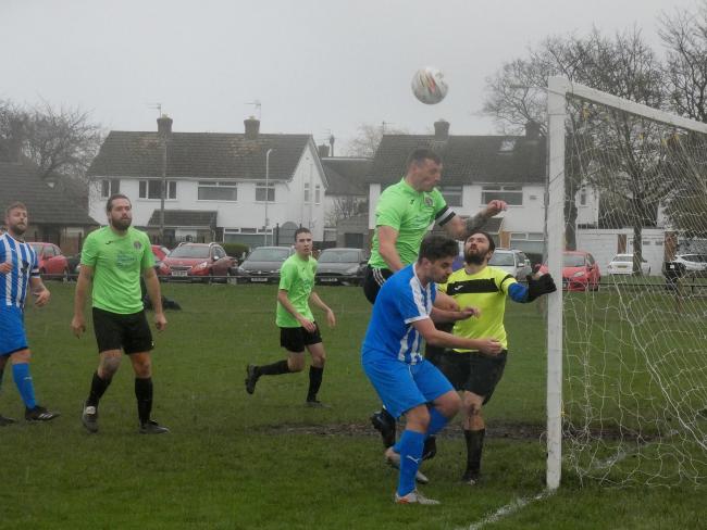 Wirral Athletic and Old Parks battle against the elements. Photo: Bob Shaw
