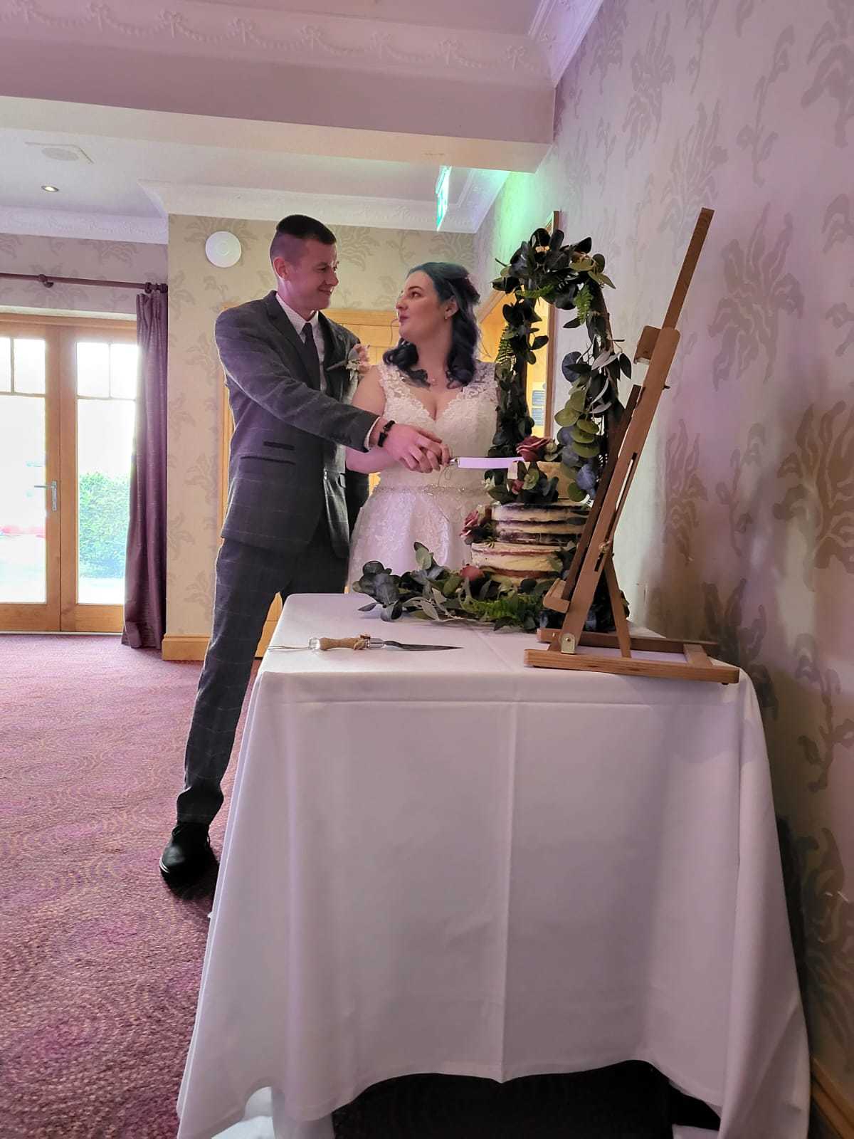 The new Mr and Mrs Povey-Dunn cutting their homemade wedding cake
