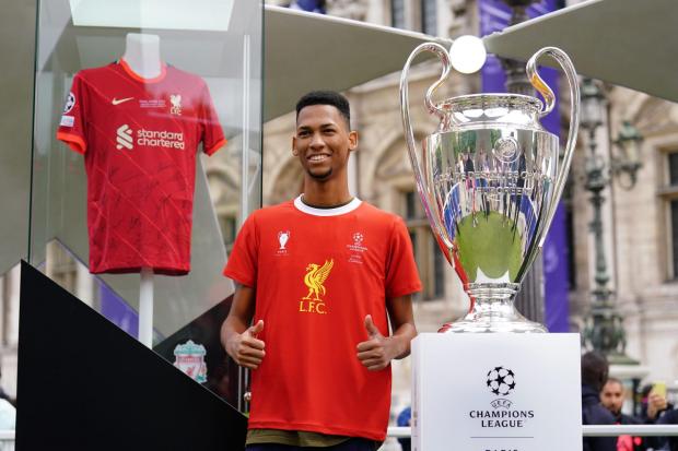 Wirral Globe: A Liverpool fan poses next to the Uefa Champions League trophy (Adam Davy/PA)