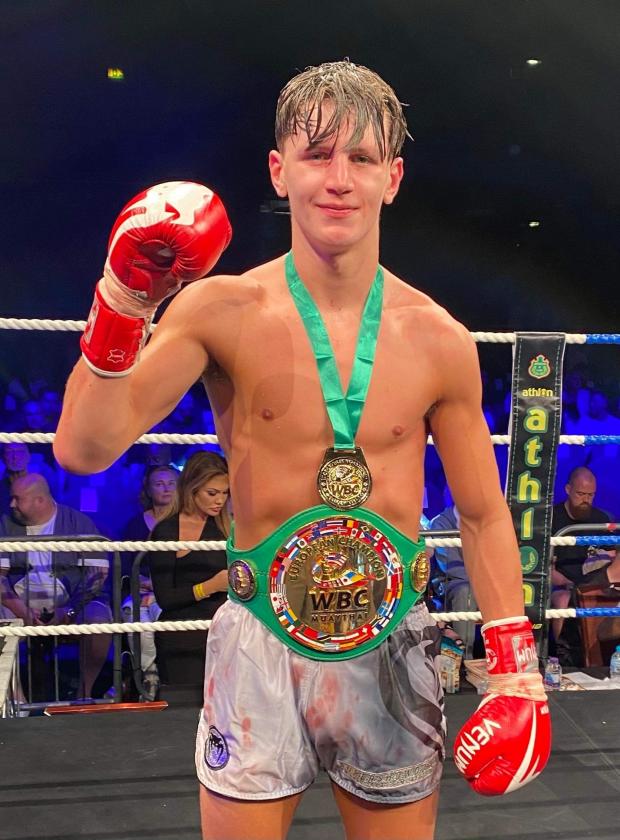 Wirral Globe:  Wirral Thai boxer Joe Ryan, 18, with the British flag after beating Madrid fighter Jose Hita at the University of Bolton Stadium to become the youngest WBC European Champion on record Picture: Michael Howarth (@mickhowarth)
