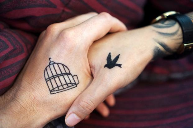 Wirral Globe: Two people with tattoos holding hands (Canva)