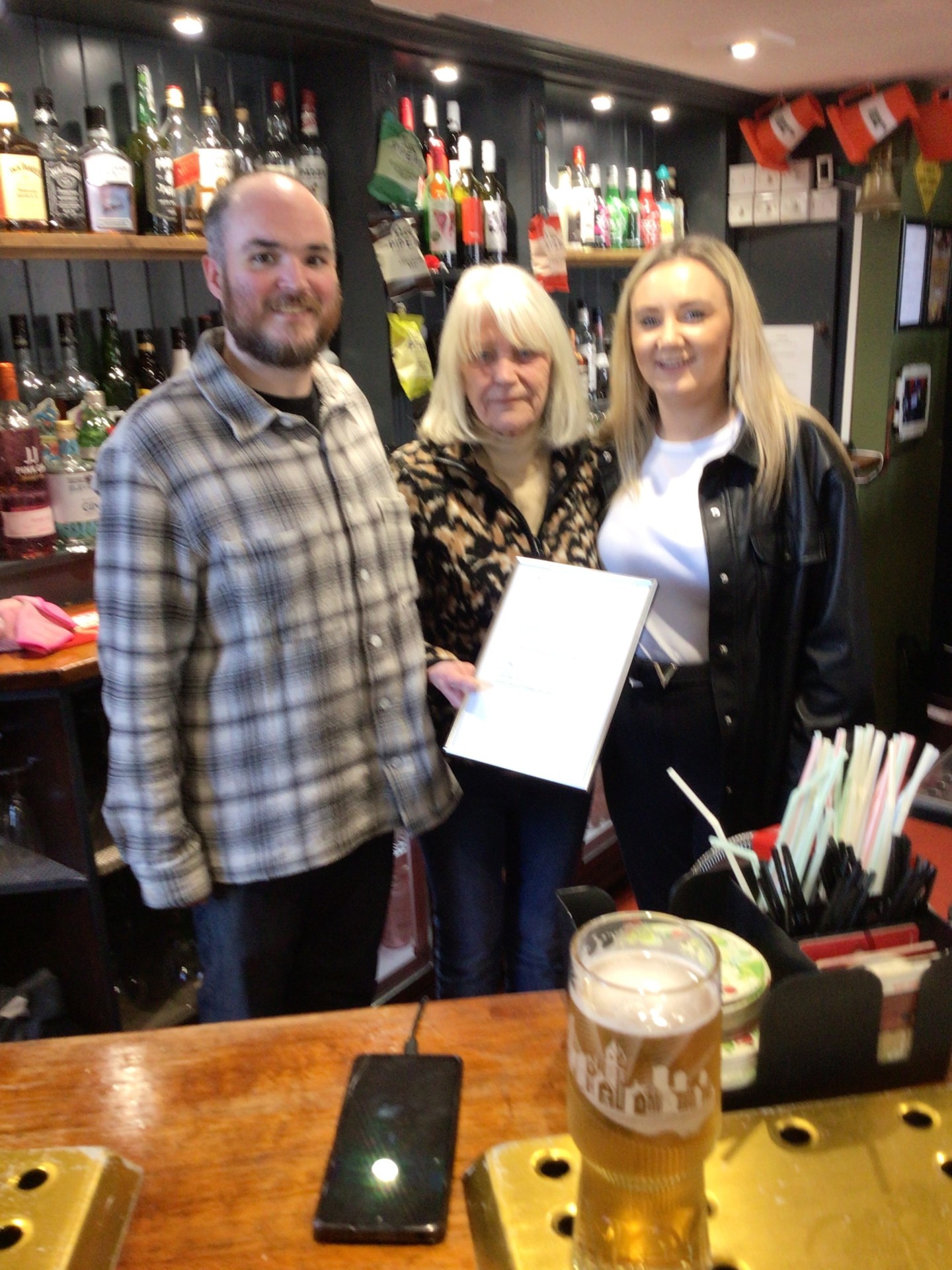 Eira Hughes presents Rob and Cassie at the Bridge Inn with a certificate of thanks from The Martin Gallier Project.