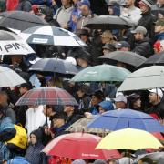 Spectators shelter under umbrella as rain falls during day four of The Open at Royal Liverpool, Wirral.