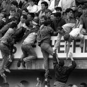 Liverpool supporters climbing to safety during the Liverpool v Nottingham Forest FA Cup semi-final football match at Hillsborough which led to the deaths of 97 people