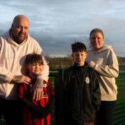 John Eccles, co-founded the Woodchurch Juniors FC. Pictured with his family in front of the estate\'s new football pitches.