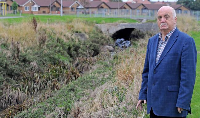 Cllr Chris Blakeley at the dam on the Arrow Brook in Moreton.